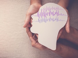 Adult and child hands holding brain paper cutout showing the brain waves that are common with seizures