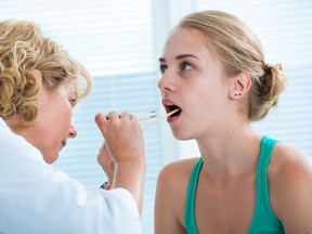 Teen opening her mouth for a checkup during a doctor appointment
