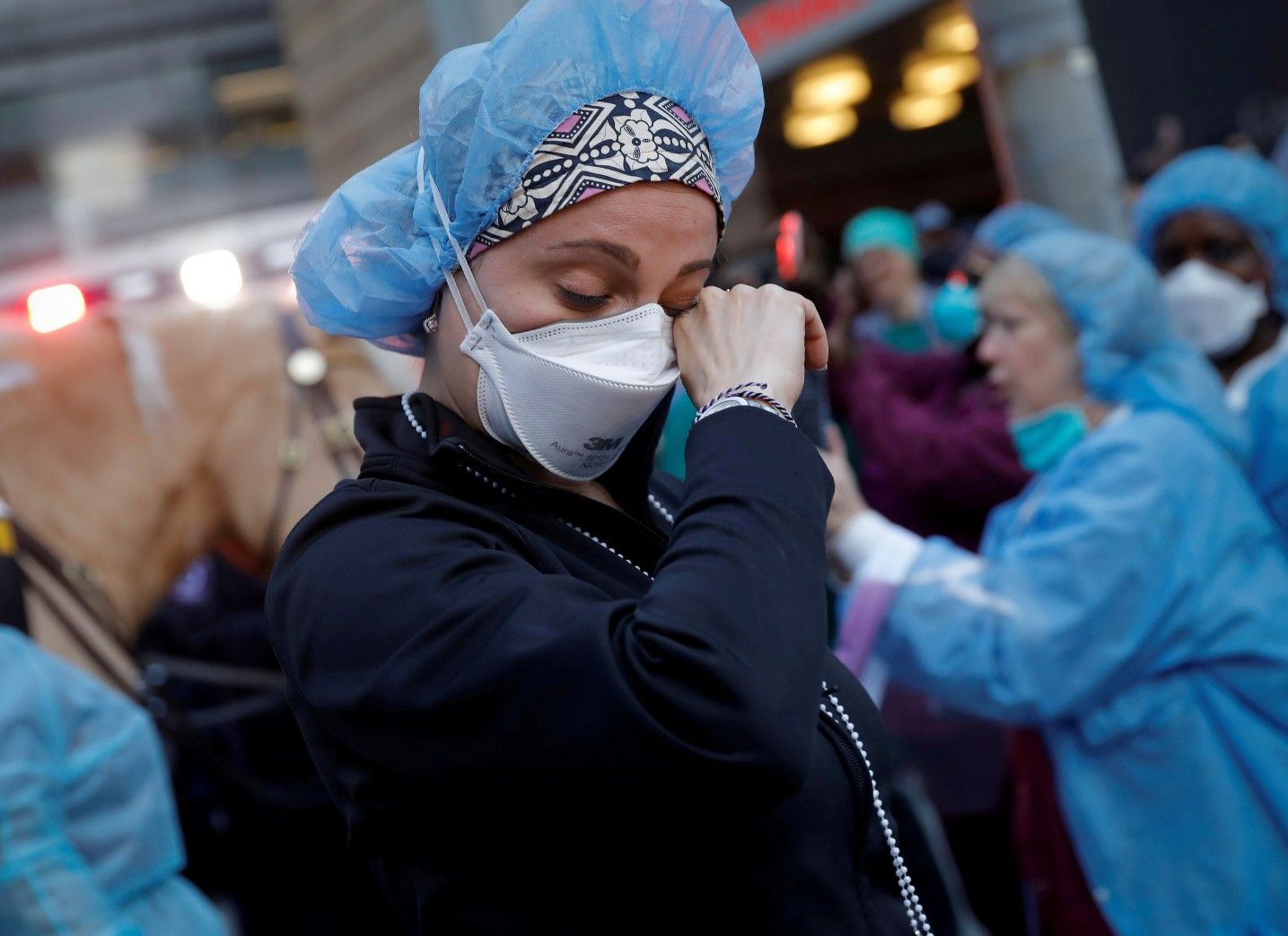  A nurse wipes away tears as she stands outside NYU Langone Medical Center on 1st Avenue in Manhattan as New York police came to cheer and thank healthcare workers in New York City, New York, U.S., April 16, 2020.