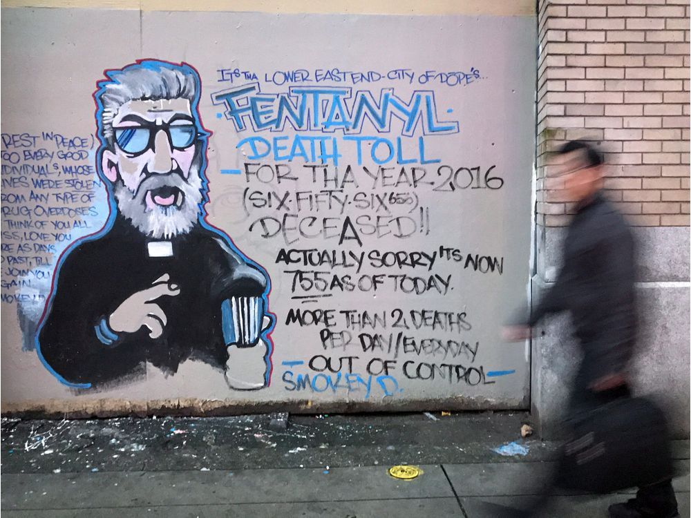 A man walks past a mural by street artist Smokey D. about the fentanyl and opioid overdose crisis, in the Downtown Eastside of Vancouver, B.C., on Thursday December 22, 2016.