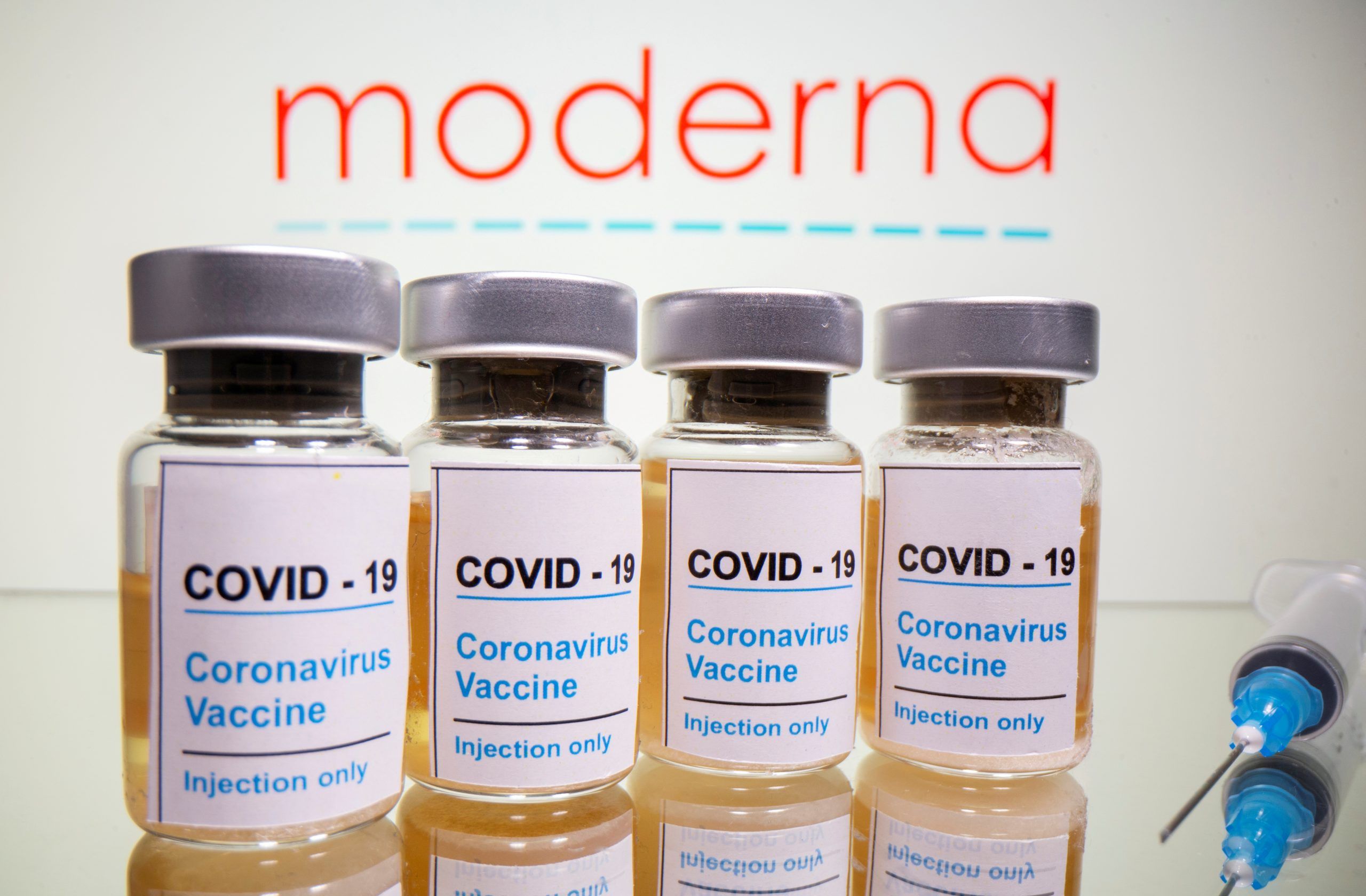 FILE PHOTO: Vials with a sticker reading, "COVID-19 / Coronavirus vaccine / Injection only" and a medical syringe are seen in front of a displayed Moderna logo in this illustration taken October 31, 2020. REUTERS/Dado Ruvic/Illustration/File Photo ORG XMIT: FW1