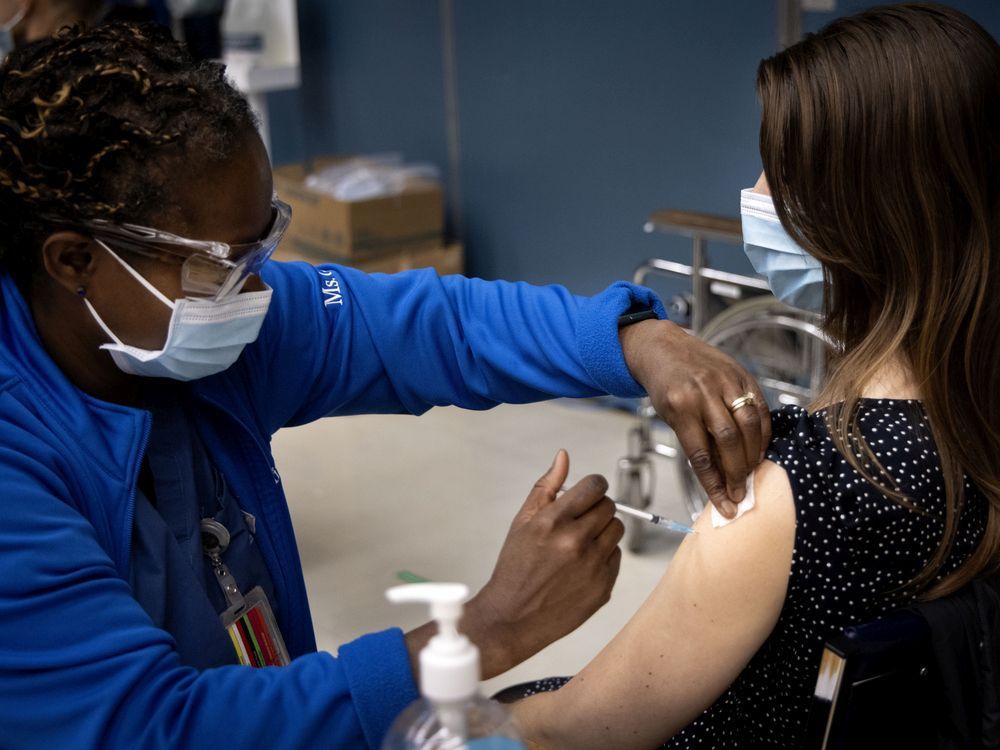 Nurse Gina Valcourt administers the Pfizer-BioNTech COVID-19 vaccine to Dr. Samatha Kellett on Friday.