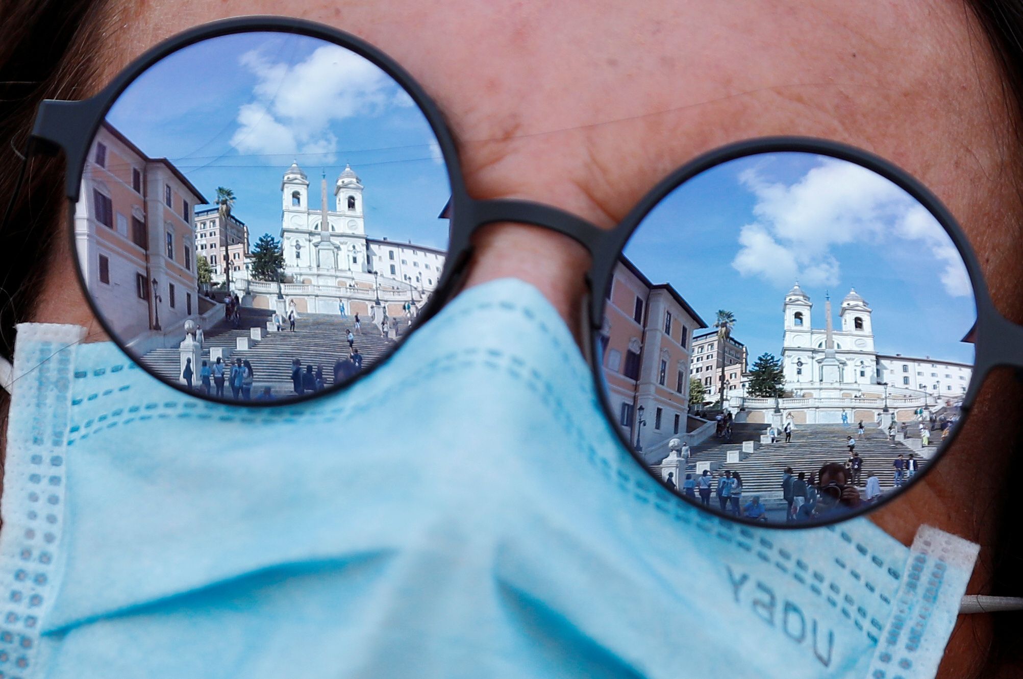 The Spanish Steps are reflected in a sunglasses of a woman wearing a face mask, as local authorities in the Italian capital Rome order face coverings to be worn at all times out of doors in an effort to counter rising coronavirus disease (COVID-19) infections, in Rome, Italy October 2, 2020.  