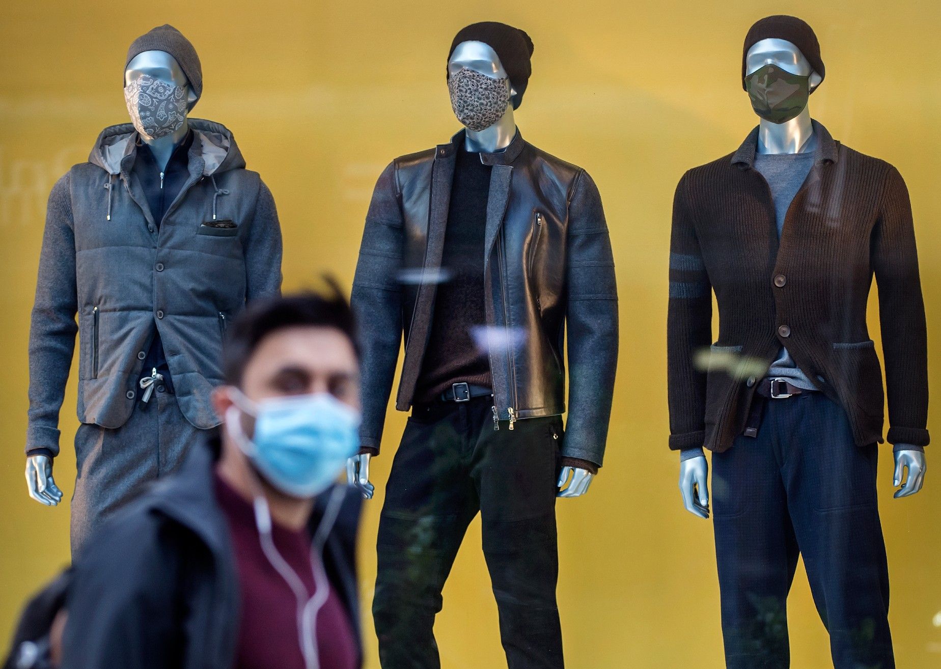 A pedestrian wearing a mask walks through Yorkville with mannequins wearing masks in a clothing store window during the Covid 19 Pandemic, Monday October 5, 2020. 
