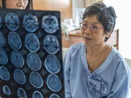 elderly woman looks at scans of her brain