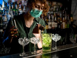 bartender with mask on pouring drinks