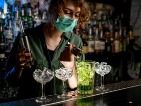 bartender with mask on pouring drinks