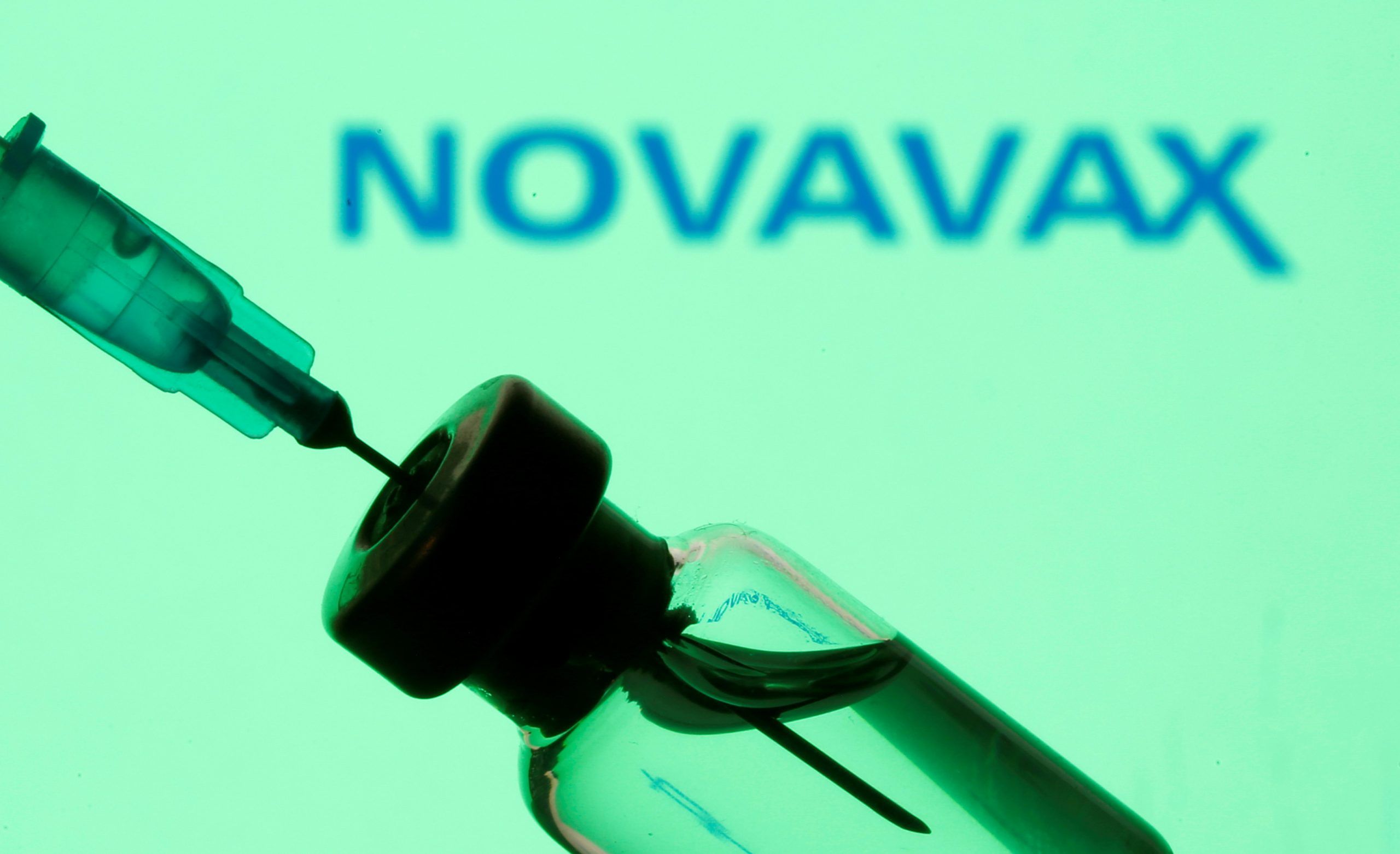 A vial and sryinge are seen in front of a displayed Novavax logo in this illustration taken January 11, 2021. 