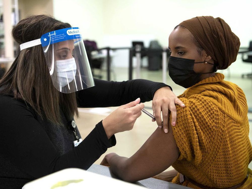 Sahra Kaahiye, a respiratory therapist at the University of Alberta Hospital, receives the COVID-19 vaccine.