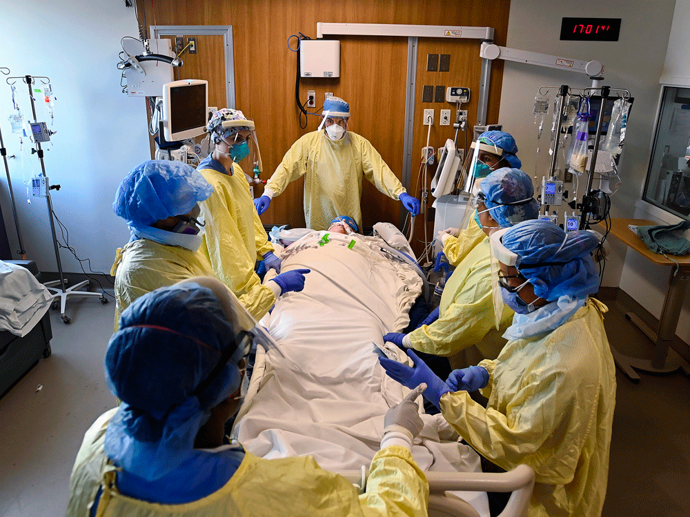 Healthcare workers get ready to prone a 47-year-old woman who has COVID-19 and is intubated on a ventilator in the intensive care unit at Toronto's Humber River Hospital on Tuesday, April 13, 2021.
