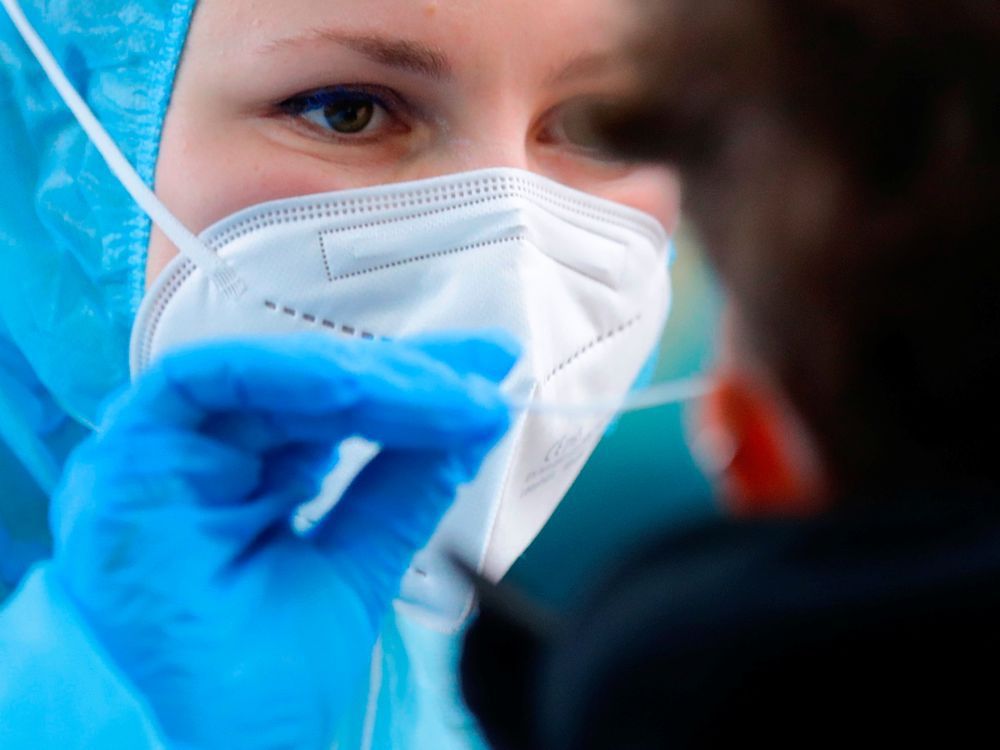 file: a medical worker takes a swab sample at a walk-in covid-19 testing centre.