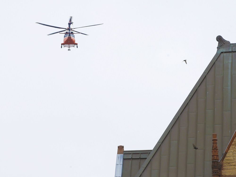 An Ornge emergency transport helicopter flies through the downtown Toronto core.