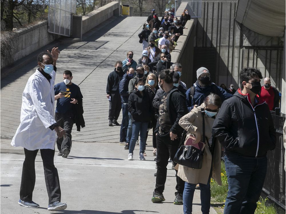 Yves Dorismond directs people outside the Olympic Stadium waiting to get their COVID-19 vaccination on May 6, 2021.