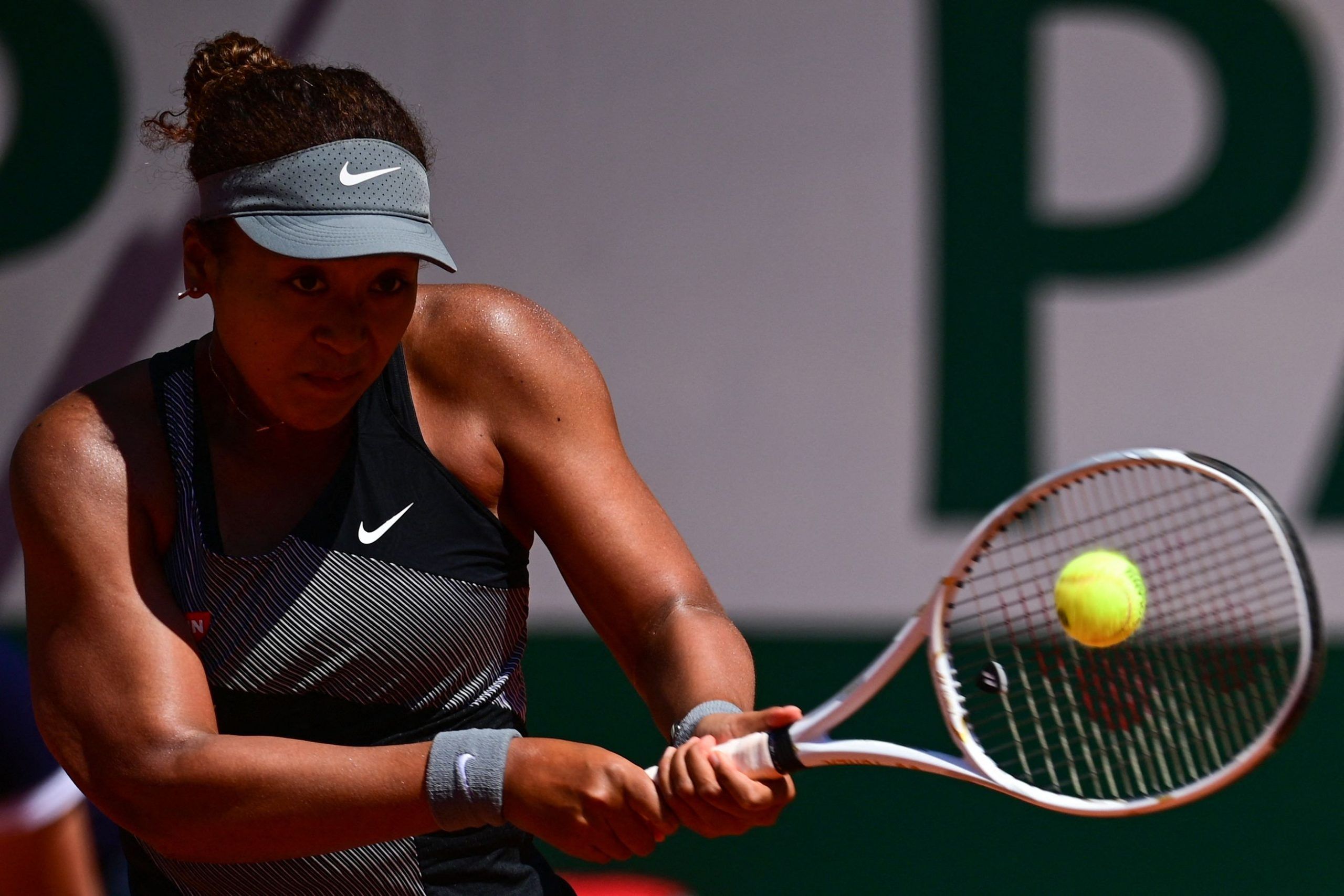 Japan's Naomi Osaka returns the ball to Romania's Patricia Maria Tig on May 30, 2021. (Photo by MARTIN BUREAU / AFP) (Photo by MARTIN BUREAU/AFP via Getty Images)