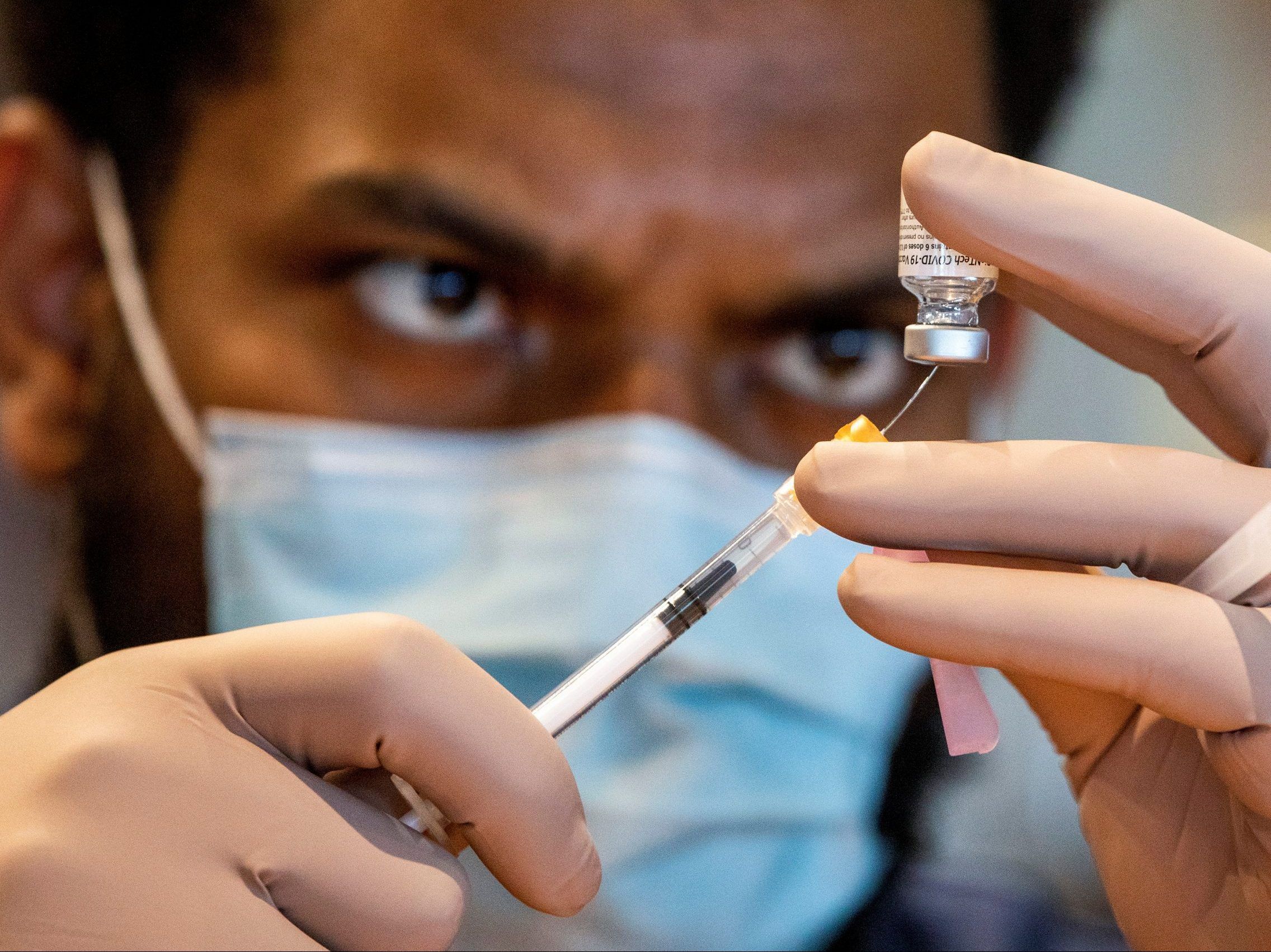 A health-care worker prepares a dose of the Pfizer/BioNTech COVID-19 vaccine at Woodbine Racetrack pop-up vaccine clinic in Toronto, May 5, 2021.