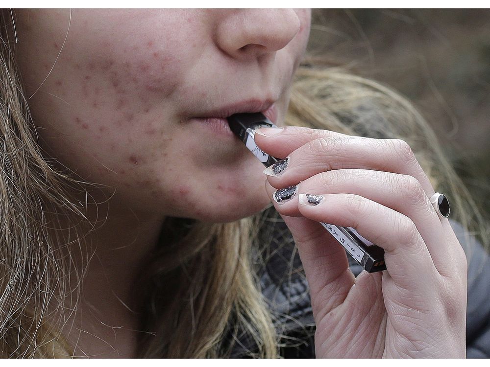 a high school student uses a vaping device. it's time for governments to take more action against big tobacco.