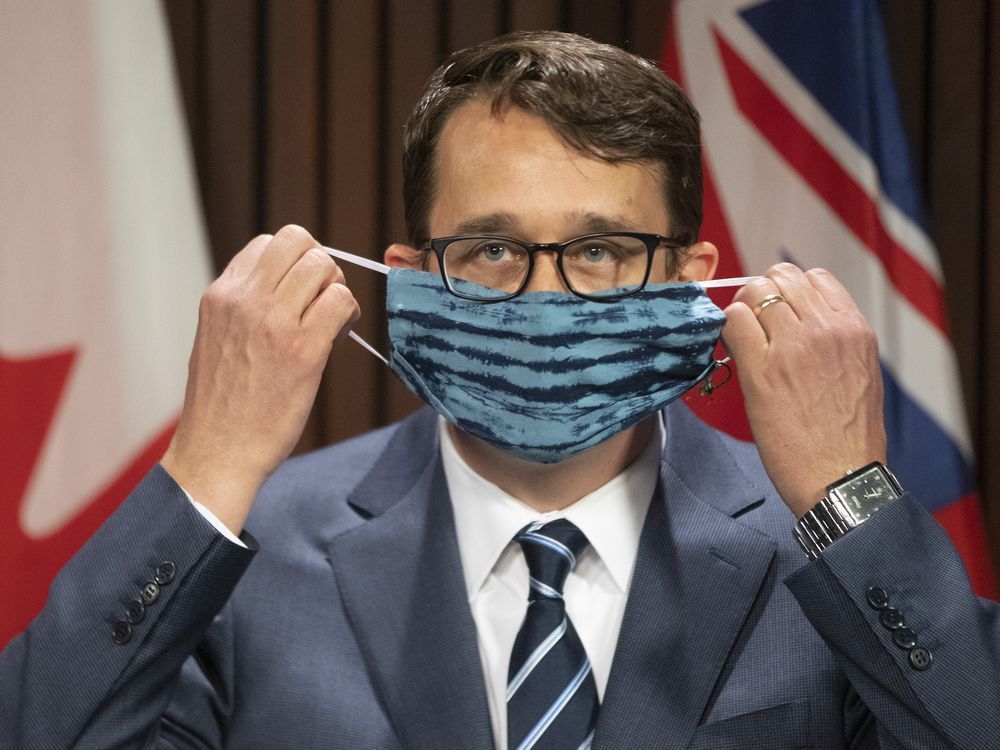 ontario labour minister monte mcnaughton removes his mask as he takes to the podium last week to announce three days of paid sick leave in ontario.