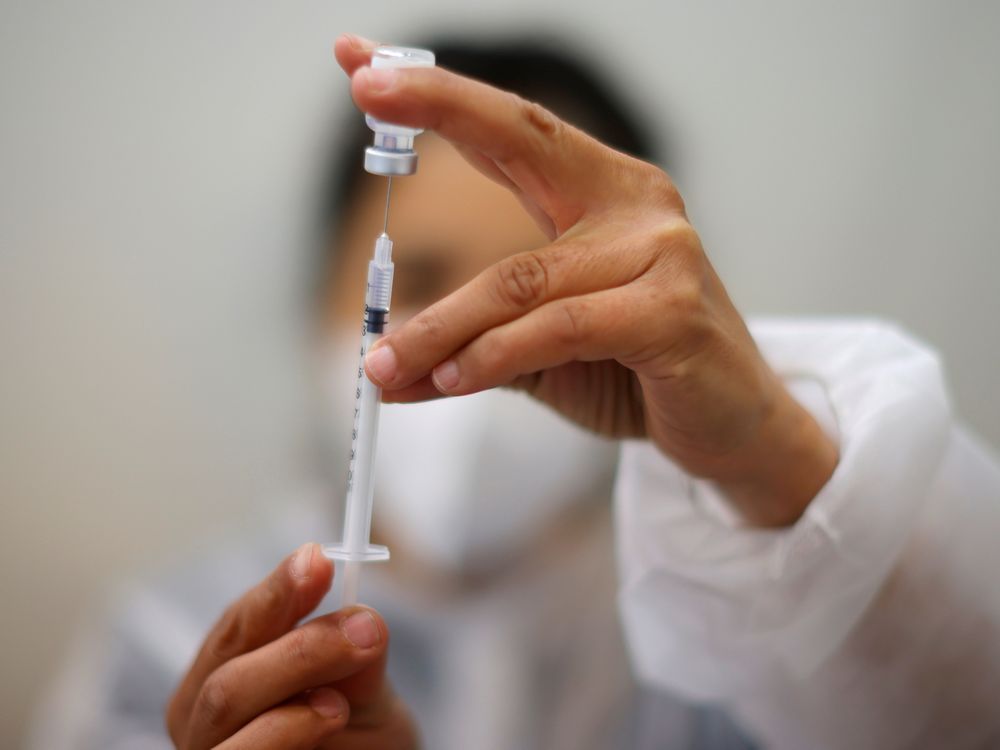 a medical worker prepares a dose of the pfizer-biontech covid-19 vaccine.