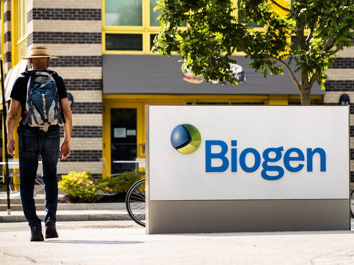 A pedestrian walks past Biogen Inc. headquarters in Cambridge, Massachusetts, U.S., on Monday, June 7, 2021. 