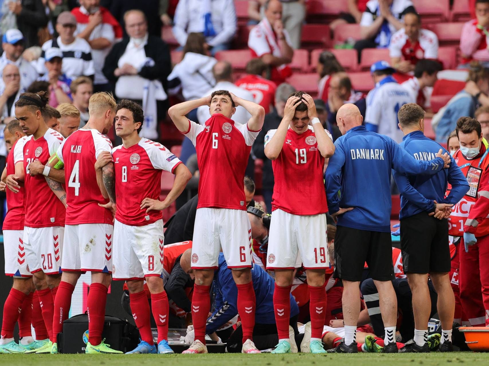 Denmark's players react as paramedics attend to Denmark's midfielder Christian Eriksen after he collapsed on the pitch during the UEFA EURO 2020 Group B football match between Denmark and Finland at the Parken Stadium in Copenhagen on June 12, 2021.