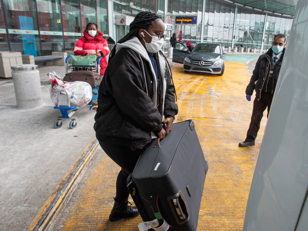 international air travellers load their luggage onto a shuttle bus to take them to one of the quarantine hotels monday, february 22, 2021 in montreal.