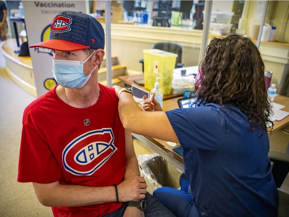 montreal canadiens fan michael scott looks away as nurse daniele richard vaccinates him during vaccination clinic for people with an intellectual deficiency or on the autism spectrum at the douglas institute in the verdun borough of montreal wednesday june 30, 2021.