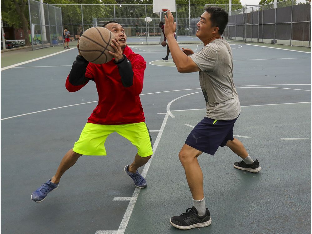 Juno Isasi, left, plays basketball with Fei Wang in Martin Luther King Park in Montreal Tuesday July 6, 2021.