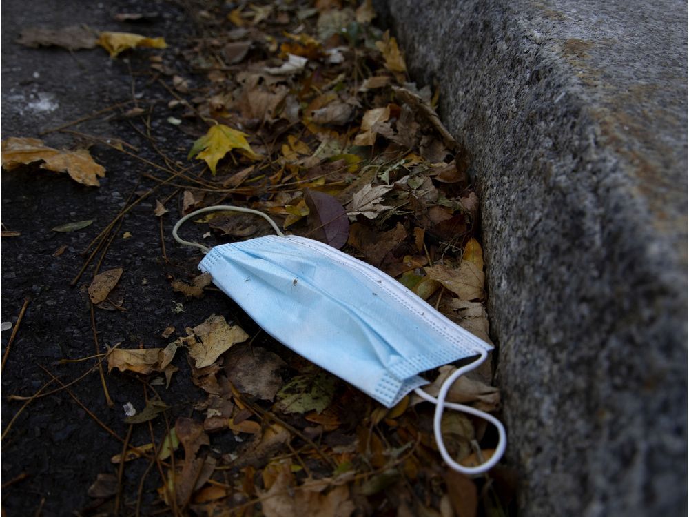 a file photo of a discarded mask on a street.