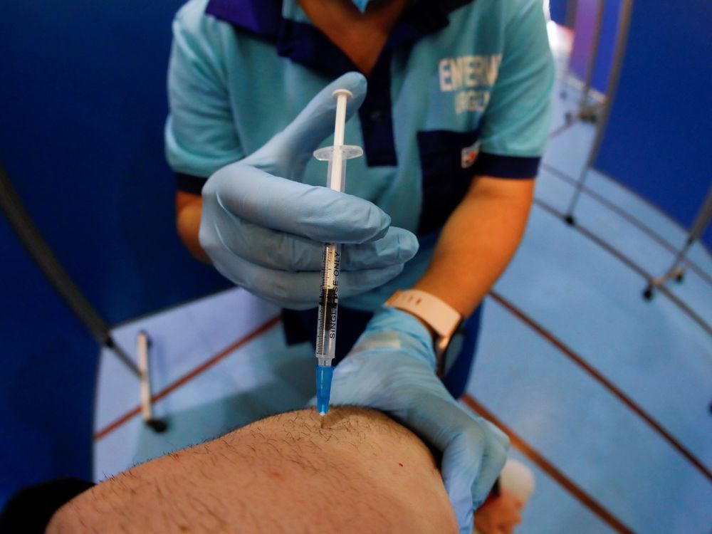 a health care worker administers the pfizer biontech covid-19 vaccine