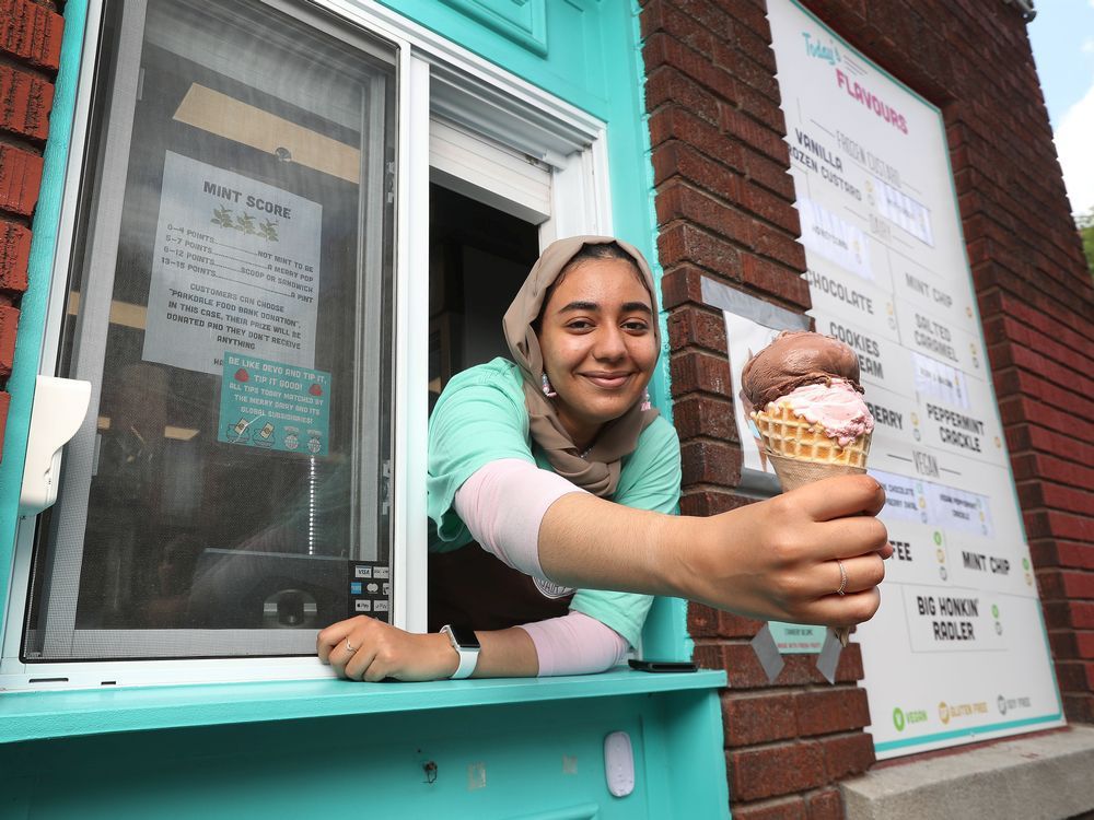 ashrakat elboraey, who agreed to remove her mask for this photo, serves ice cream at the merry dairy in ottawa.