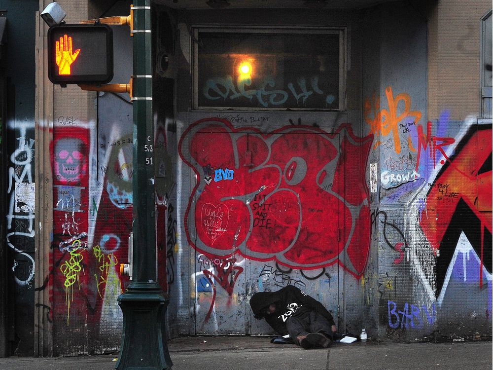 A homeless man huddles on the street in Vancouver's Downtown Eastside.