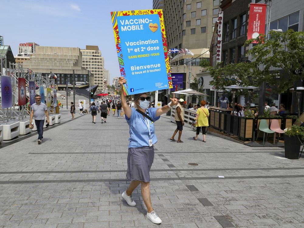 marie-hélène from the ciusss centre-sud de montréal carries a sign as she tries to recruit people to get vaccinated against covid-19 at a mobile vaccination clinic in place des festivals in montreal sunday august 8, 2021.