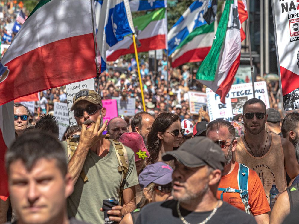 a protester in montreal on aug. 14, 2021, wears a yellow star of david, like those jews were made to wear in nazi germany, during a rally against quebec's covid-19 health measures