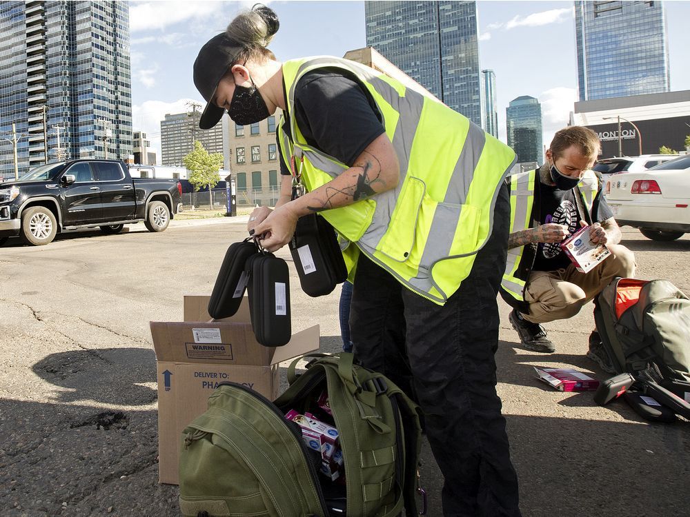 Boots on Ground street outreach and harm reduction members Alyssa Miller and Dave McLennan pack supplies as they prepare to head out into downtown Edmonton, Wednesday Aug. 11, 2021.