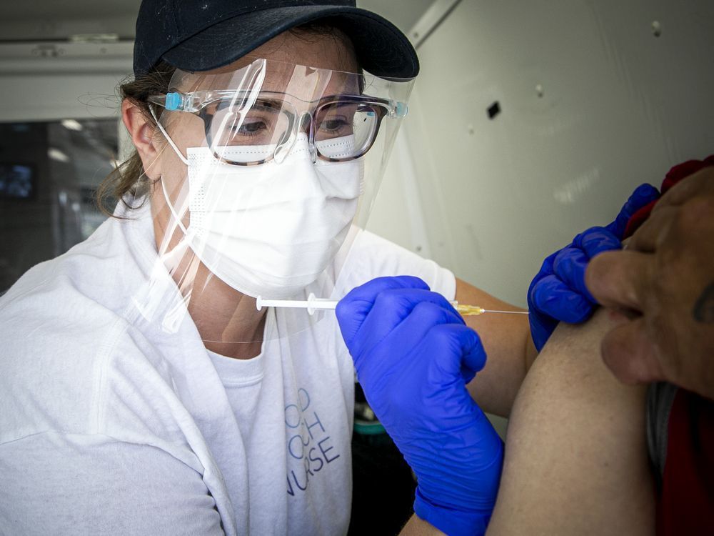 beth lusk, an ottawa inner city health nurse, delivers a vaccination at the shepherds of good hope on friday.