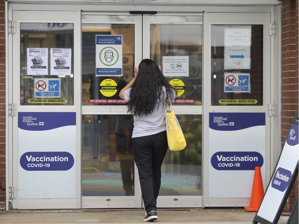 a woman enters the covid-19 vaccination clinic at the bob birnie arena in pointe claire, west of montreal thursday august 19, 2021.