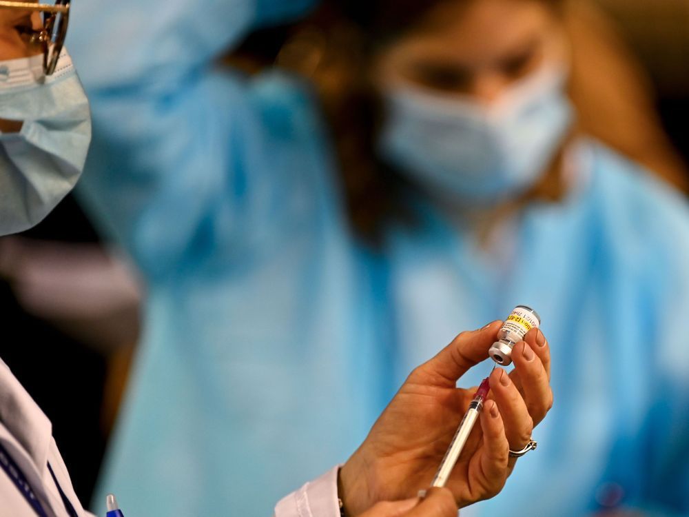 a health worker prepares an injection of a covid-19 vaccine.