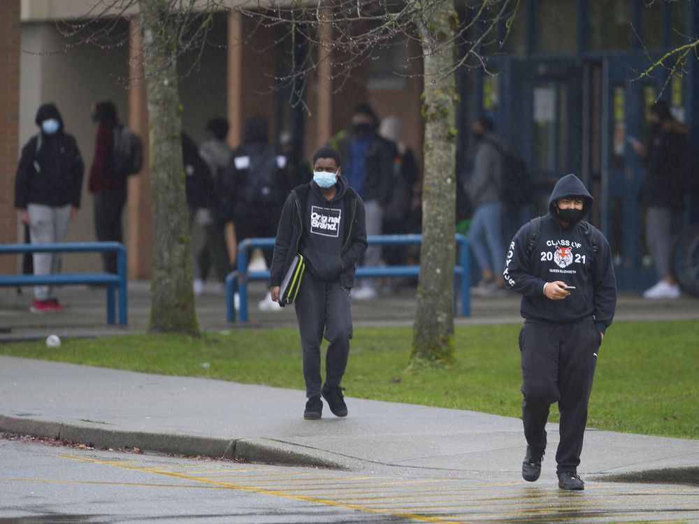 students wearing masks leave queen elizabeth secondary school in surrey in february.