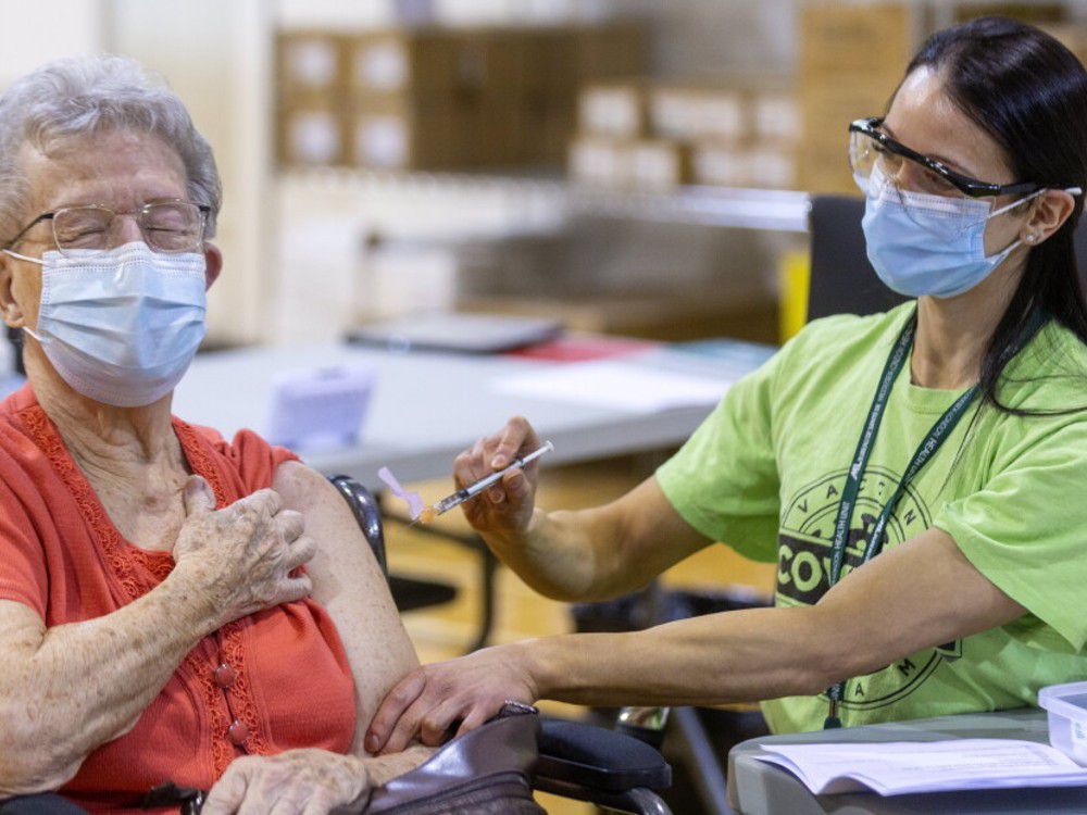 shirley banks, 88, flinches a bit in anticipation of getting her needle, wielded by public health nurse stephanie mckee as the first covid-19 vaccine was injected at the north london optimist centre on cheapside street in london, ont.