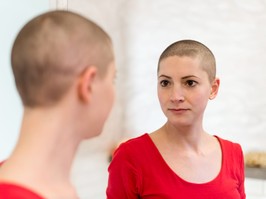 woman with cancer looking into mirror