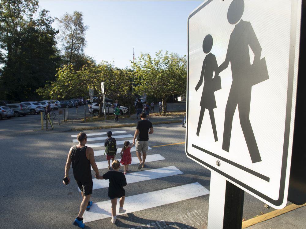 children walk with their parents to sherwood park elementary in north vancouver for the first day back-to-school thursday, september 10, 2020.