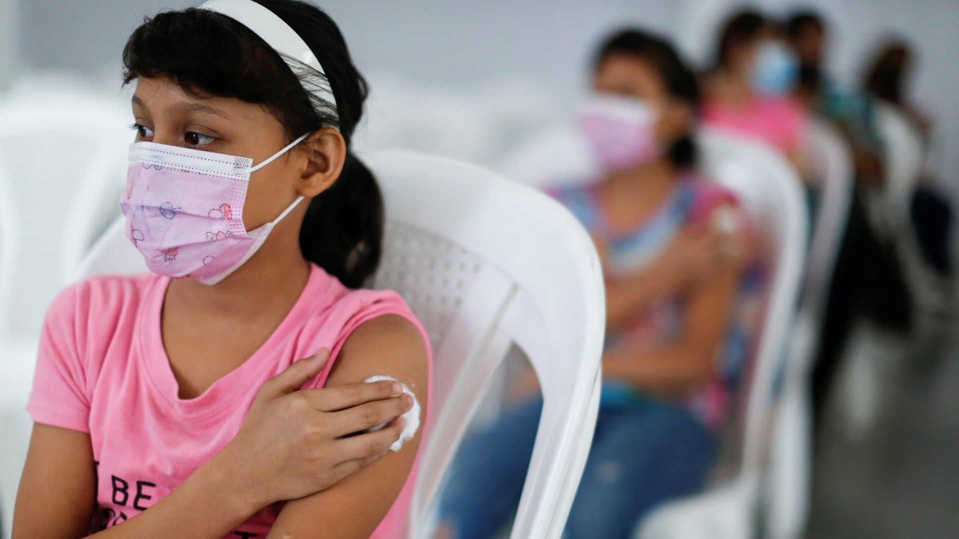 twins ashley nahomy and angie gisella avila navas, 11, wait after receiving a covid vaccine in san salvador, el salvador. canada will receive millions of pfizer vaccines intended for children once they're approved. (jose cabezas / reuters)