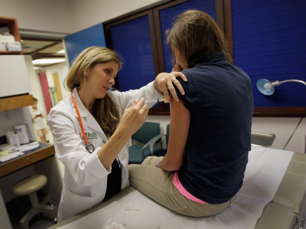 university of miami pediatrician judith l. schaechter, m.d. (l) gives an hpv vaccination to a 13-year-old girl in her office at the miller school of medicine on september 21, 2011 in miami, florida. the vaccine for human papillomavirus, or hpv, is given to prevent a sexually transmitted infection that can cause cancer.