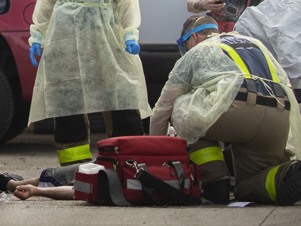 EMS paramedics and Windsor firefighters are shown May 28, 2020, working on a man suspected of having overdosed on fentanyl as he lies on the pavement east of the downtown.