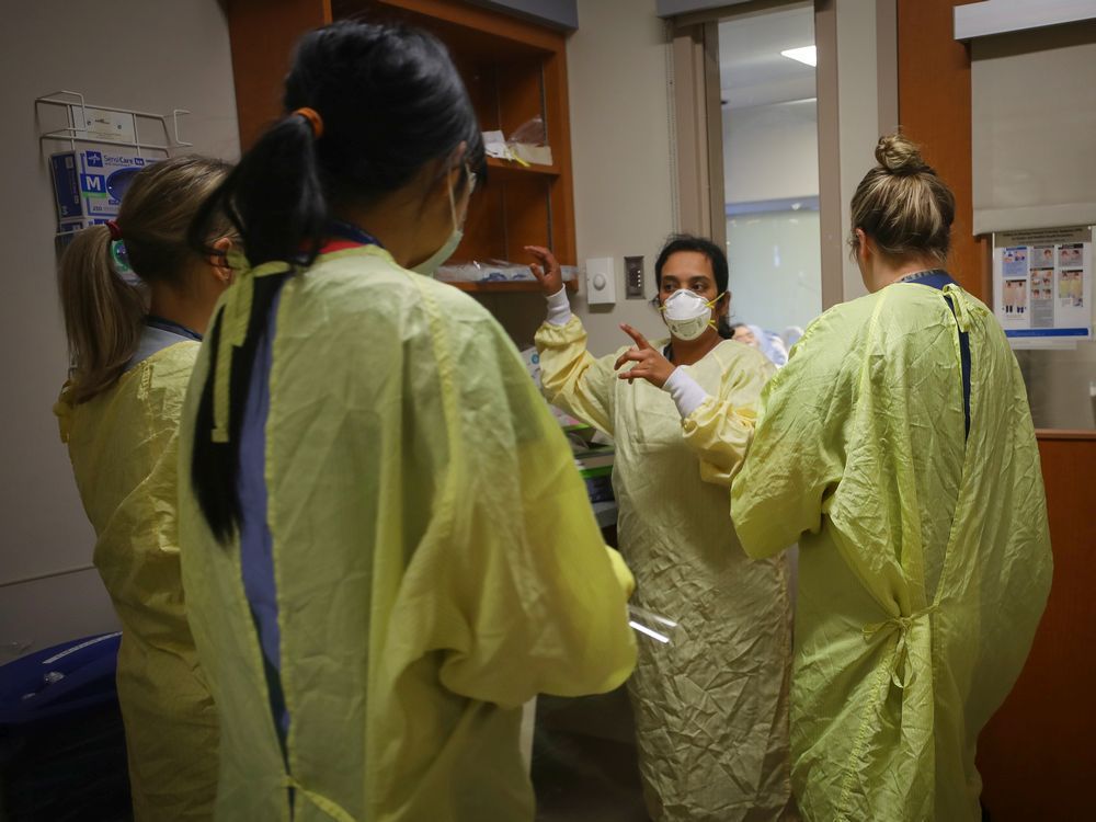 nurses get ready before going into assist a covid-19 patient on the intensive care unit at peter lougheed in calgary on nov. 14, 2020.