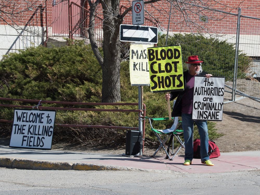 An anti-vaccination protester stands outside the Regina General Hospital in Regina, Saskatchewan on April 21, 2021.