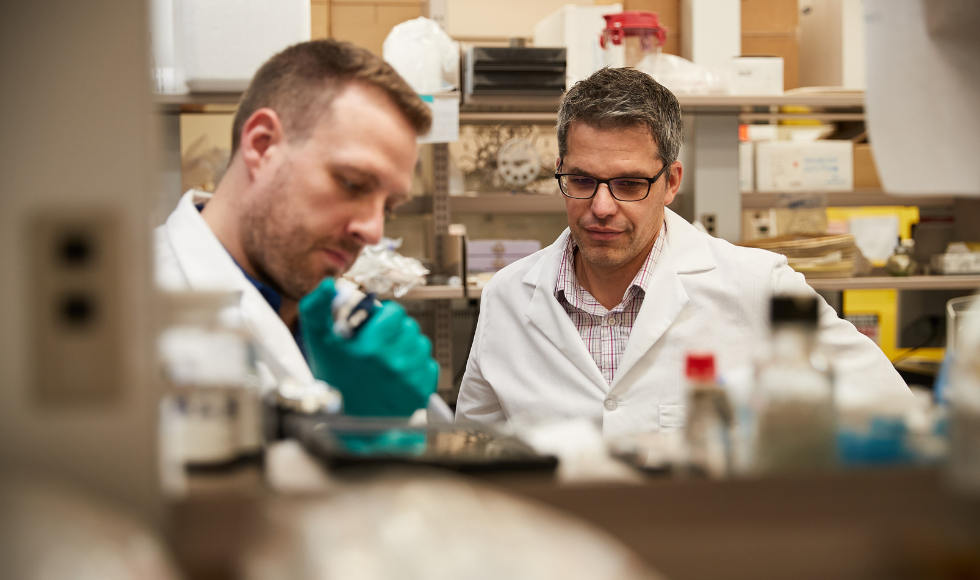 Former McMaster post-doctoral researcher Ryan Shaler, left, and Brian Coombes, a McMaster biochemistry and biomedical sciences professor, work together in a lab. (BrighterWorld)