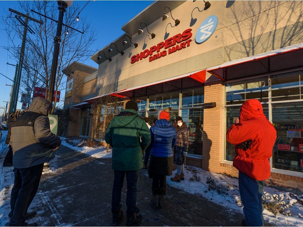 calgarians brave the cold to stand in line outside the shoppers drug mart in kensington to pick up their free covid-19 rapid test on friday, december 17, 2021. the line-up continues inside the store and it takes an average of one hour for each person to get their kit. azin ghaffari/postmedia