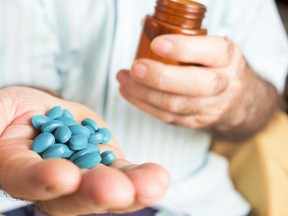 old man with a pile of pills in his hand