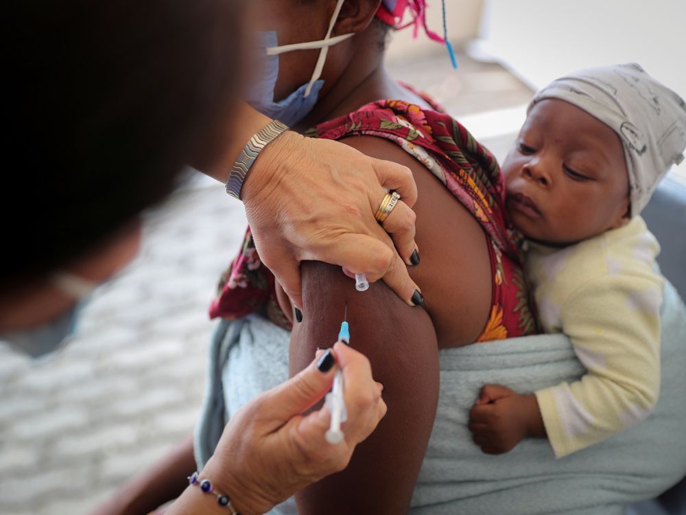 A health care worker administers the COVID-19 vaccine to a young mother in Johannesburg, South Africa, December 04, 2021.